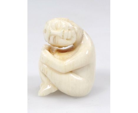 A Japanese Taisho period ivory netsuke, formed as a gentleman with head turned, in a crouched position, marked 4/1 beneath, 2