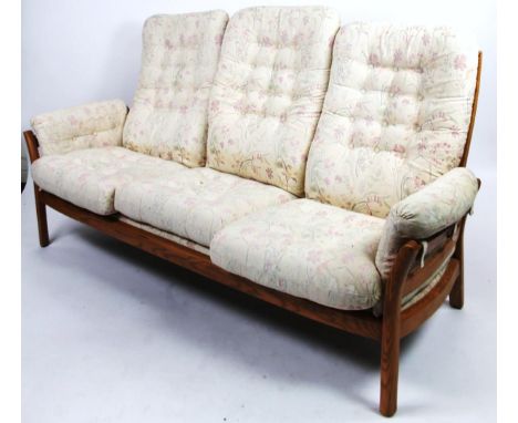 A light Ercol three seater cottage settee, with floral cushions on block supports, 188cm wide.