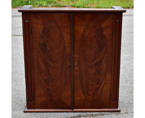 An Edwardian two door table top cupboard, with oval panelled doors enclosing a shelf, height approx 57cm, width approx 55cm, 