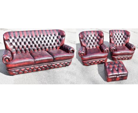 A modern red leather Chesterfield four piece suite comprising three seater sofa, pair of armchairs, each with button back mat