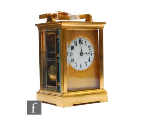 A late 19th and early 20th Century brass carriage clock, circular Arabic dial, bevelled glazed sides on bracket plinth, with 