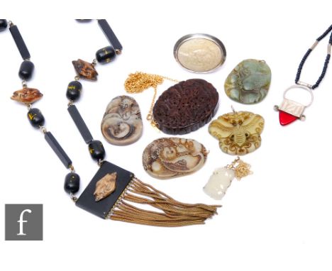 A small parcel lot of assorted Asian jewellery items to include a jade pendant, a carved mother or pearl brooch, beads, a car