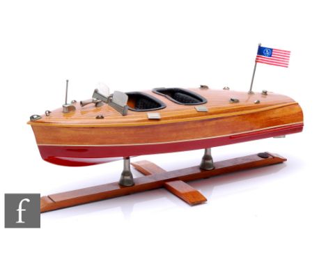 A post 1950s wooden scale model of a two seater motor launch with metal deck fittings and flag pennant, on twin supports and 