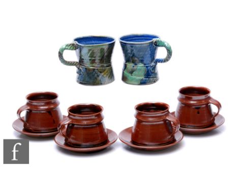 A pair of studio pottery salt-glaze mugs by Jane Hamlyn, of waisted cylinder form with twisted loop handle, decorated with in