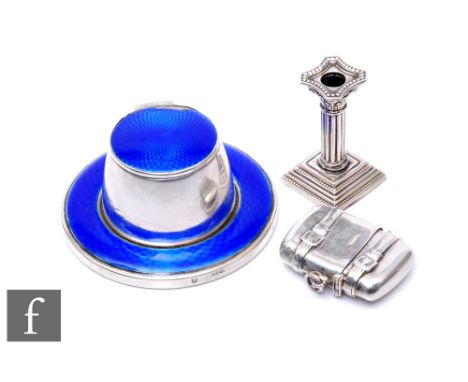 A hallmarked silver miniature Corinthian column candlestick, height 5.5cm and a silver and blue enamelled capstan ink well, d