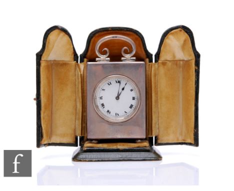 A hallmarked silver carriage clock of plain form, Roman numerals to a white enamelled dial below scroll carrying handle, heig
