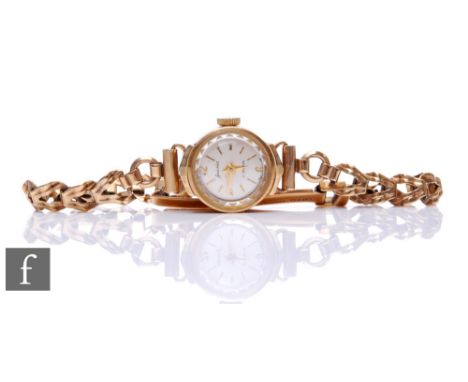 A lady's 9ct hallmarked Accurist manual wind wrist watch, batons to a silvered circular dial and 9ct bracelet, total weight 1