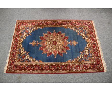 A PERSIAN BLUE GROUND AND RED DESIGN RUG, 180cm x 122cm.