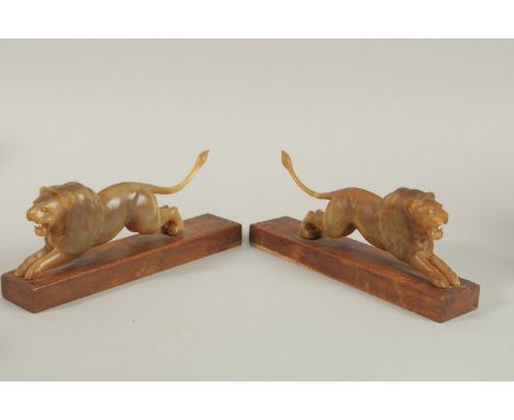 A PAIR OF 19TH CENTURY INDIAN CARVED HORN LIONS ON WOODEN STANDS, 20cm long (excl. base).