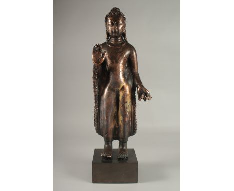 A LARGE COPPER BRONZE STANDING BUDDHA, mounted to a square form plinth, 61cm high overall.