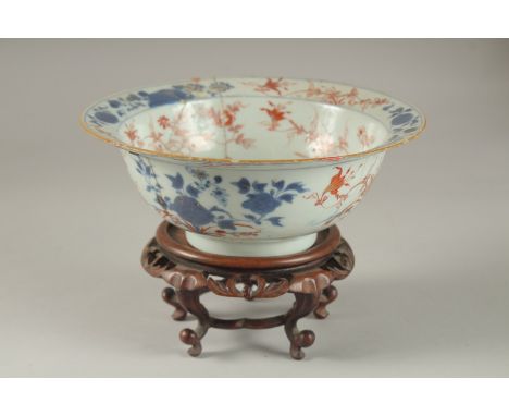 A CHINESE PORCELAIN BOWL AND HARDWOOD STAND, (af), 19cm diameter.