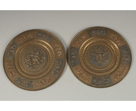 A PAIR OF 19TH CENTURY INDIAN TANJORE SILVER AND COPPER INLAID BRASS DISHES, depicting Hindu deities, 20cm diameter each.