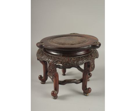 A CHINESE CARVED HARDWOOD STAND, raised on five stretchered legs, the central circular carving designed to fit a base measuri