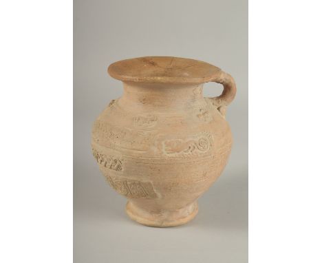 A 10TH CENTURY MIDDLE EASTERN ISLAMIC UNGLAZED POTTERY JUG, with carved calligraphy and animals, 18.5cm high.