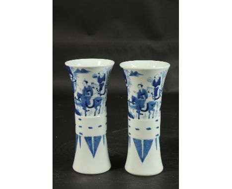 A PAIR OF CHINESE BLUE AND WHITE PORCELAIN GU SHAPE VASES, decorated with figures, 21cm high.