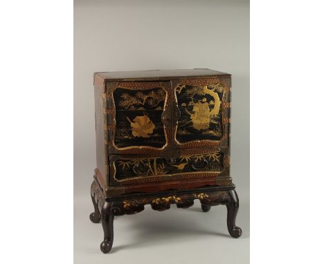 A FINE JAPANESE MEIJI PERIOD BLACK AND GILT LACQUERED CABINET, raised on stand, the two doors opening to reveal eight drawers