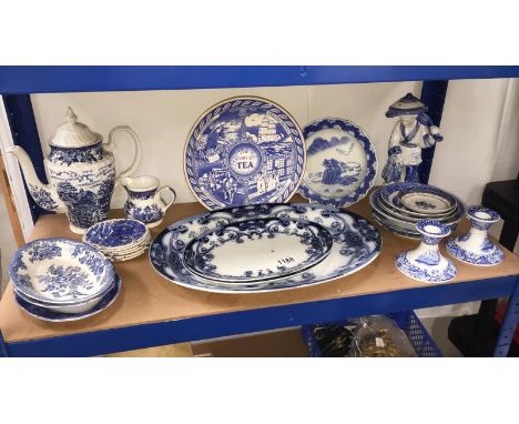 A shelf of blue and white pottery including Burslem Iris meat plates, Spode candlesticks etc.