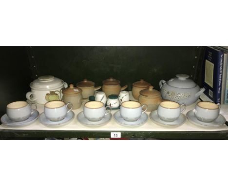 A shelf of Denby stoneware tea and dinner ware