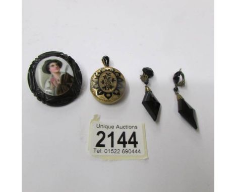 An antique painted porcelain brooch of a young boy on a jet mount together with a yellow metal memorial opening locket and a 