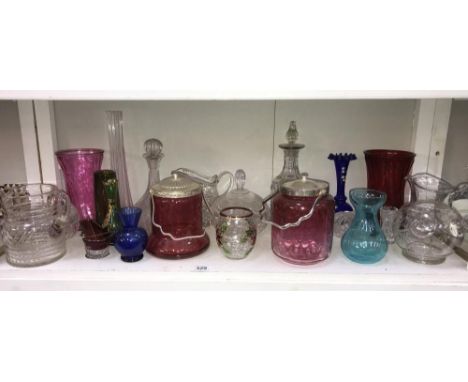 A shelf of glass biscuit barrels, jugs, vases including cranberry etc.