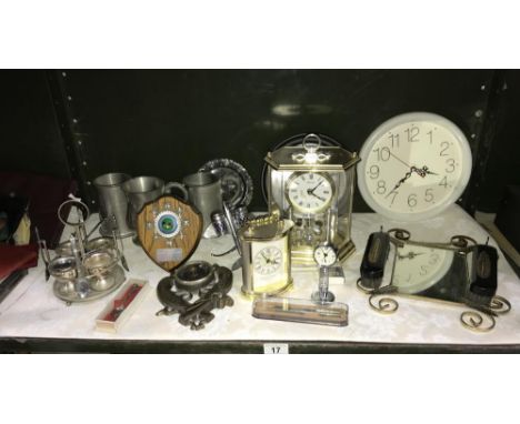 A shelf of clocks, pewter tankards, aeroplane cruet etc.