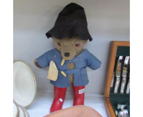 A Paddington bear soft toy figure featuring black hat and red Dunlop Wellington boots.