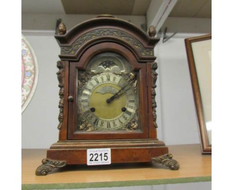 An ornate bracket clock with fretwork panels and moon phase dial marked W C Pales, London.