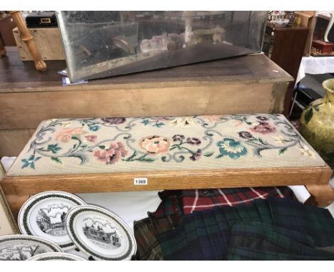 A long oak footstool with tapestry top