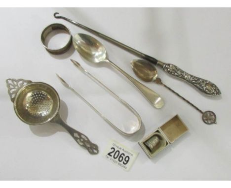 A silver handled button hook, a silver tea strainers, silver sugar nips, silver spoons etc.,