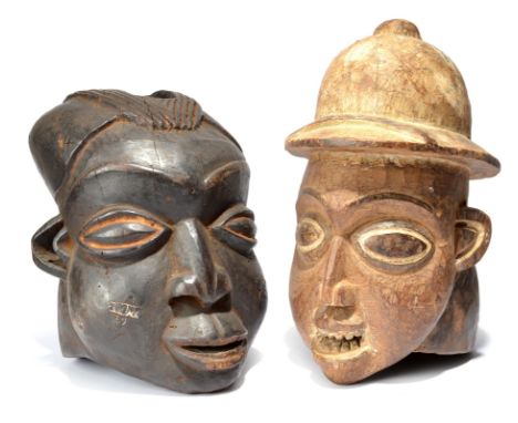 Two Bamileke helmet masks Cameroon one wearing a pith helmet, the other with an aperture to the top of the head, 38cm and 31c