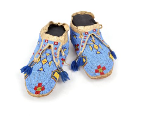 A pair of Lakota moccasins Plains hide with light and dark blue, red, white, yellow and green glass bead decoration, with for