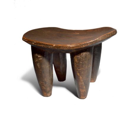 A Senufo stool Ivory Coast with a dished seat and facet tapering legs, 28.5cm high, 39cm wide.