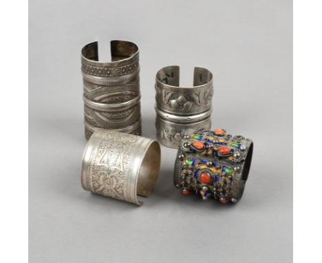 Four North African cuff bracelets silver coloured metal, including Siwa with bird and foliate embossed decoration, hallmarks,