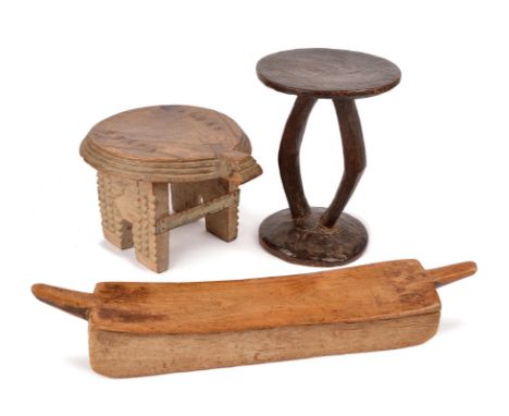 A Lobi low stool Burkina Faso with end lifts and sledge feet, 65.5cm long, a hardwood zoomorphic stool and a West Africa twin