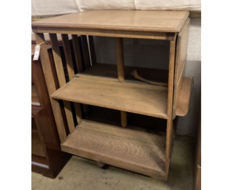 An Arts &amp; Crafts light oak drop flap revolving bookcase, with a folding reading slope, width 68cm, depth 56cm, height 90c