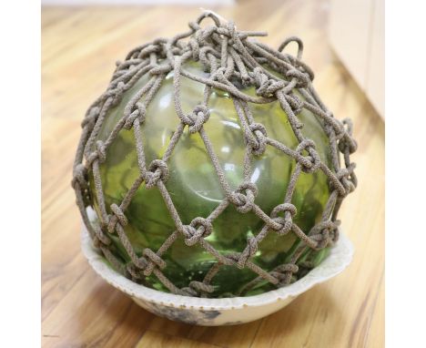 A large glass buoy with netting and a Staffordshire pottery basin