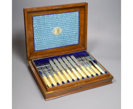 A Victorian oak cased set of twelve pairs of ivory handled silver dessert eaters, the knife blades engraved with different sp