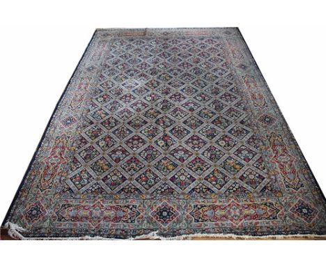 A Persian hand woven wool carpet, worked with an all over floral design within a trellis pattern against a pale blue ground, 