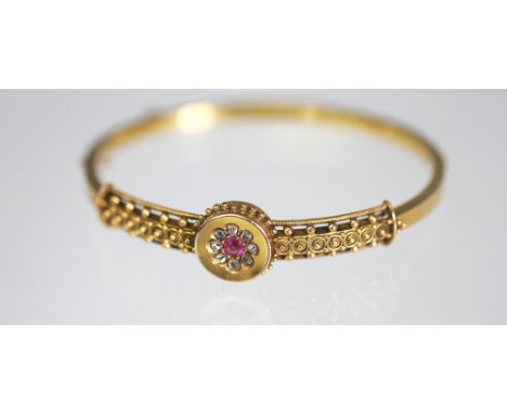 A lady's Victorian 15ct yellow gold bangle inset with rose cut diamonds and a central ruby, within cannetille work surround, 