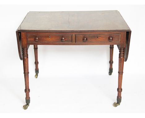 A Regency mahogany and rosewood banded sofa table, with two real and two dummy drawers, with side flaps, on turned and tapere