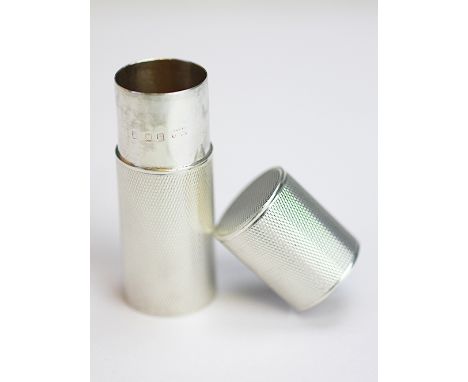 A silver needle or pill box and cover, London 1937, probably by Asprey, the cylindrical sleeve jar and cover with all-over en