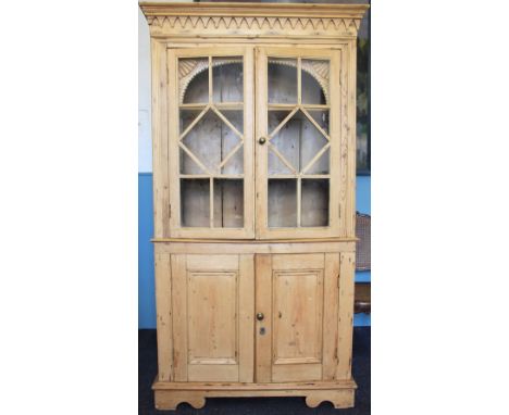 A pine kitchen kitchen display cabinet, possibly Irish, with moulded cornice above two astragal glazed doors enclosing shelve