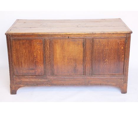 An 18th century oak coffer, with triple plank top and triple panelled front, on bracket feet, 70cm H x 128cm W x 63cm D