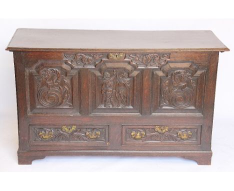 An 18th century style carved oak mule chest, late 19th century, the three panel front carved with figures and dragons, with t
