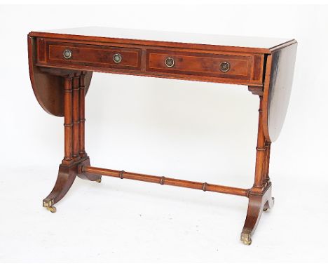 A pair of Regency style walnut and birds eye maple sofa tables, late 20th century, with two real and two dummy drawers, round