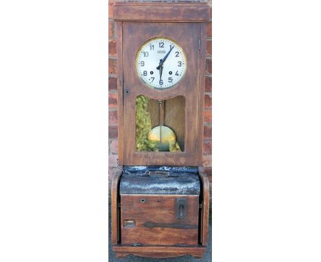 An early 20th century Synchromatic oak time recorder / clocking on clock, with Arabic dial and pendulum above an elaborate me