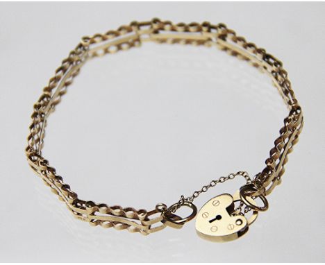 A lady's three bar gate style 9ct gold bracelet, London 1982, with an attached padlock clasp and safety chain, weight 5.3gms 