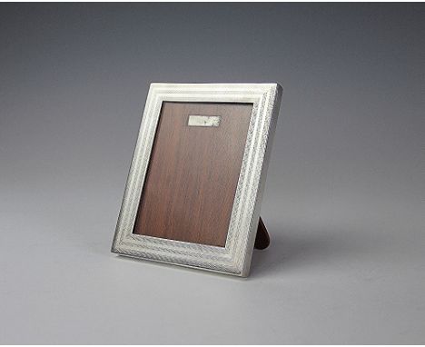 A Chinese silver frame, the rectangular frame with engine turned stripe detail and oak back with easel support, 12.5cm x 10.3