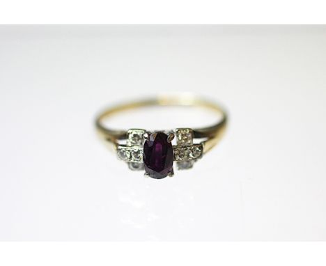 A ruby and diamond Art Deco ring, the oval, mixed cut ruby within diamond set shoulders, all set in white metal to the bifurc