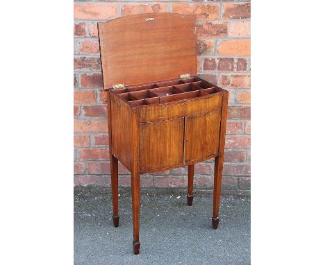 A George III mahogany bow front work cabinet, with hinged top enclosing a compartmented interior, over two cupboard doors, on